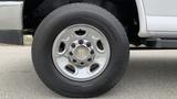 A close-up of a silver wheel of a 2017 Chevrolet Express Quigley 4x4 with a shiny chrome rim and a black tire with visible tread patterns