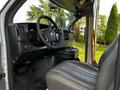 Interior view of a 2015 Chevrolet Express showing the driver's seat steering wheel dashboard and controls