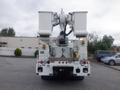 A 2009 International 7400 bucket truck with dual hydraulic lifts mounted on the rear and an extended utility platform for high access work