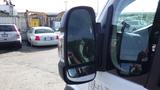 A 2017 RAM Promaster side mirror reflecting the vehicle's details and a view of cars parked nearby