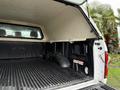 Interior view of a 2018 Ford F-150 truck bed with a cap showing a lined cargo area and the Ford logo