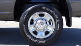 A chrome wheel of a 2014 RAM 3500 featuring a large tire with the words Dueler Hit and a sidewall branding of Bridgestone