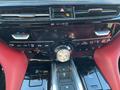 Dashboard of a 2023 Acura MDX featuring climate controls navigation buttons and a gear shift with a prominent drive mode selector in a sleek black and red design