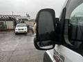 Close-up of the side mirror of a 2018 RAM Promaster showing rain droplets on the surface