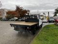 A white 2020 Ford F-350 SD with a flatbed and a metal frame in the rear