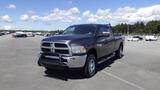 A 2014 RAM 3500 pickup truck with a dark gray exterior and chrome accents parked on a lot