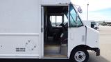 A white 2011 Ford Econoline with an open side door revealing the driver's seat and interior detailing