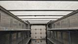 Interior view of a 2006 Ford Econoline showing metal shelving and a roof structure with a white cover