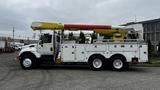 A 2006 International 7500 truck with a yellow and red aerial lift mounted on top and multiple compartments for equipment on the side