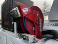 A red hose reel mounted on top of a 2018 Ford F-550 with a heavy-duty label and a metallic base attachment