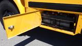 A yellow 2014 International 3000 school bus with an open battery compartment revealing black batteries inside