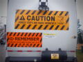 A rear view of a 2008 International 7400 truck with warning signs about vehicle movement and safety instructions on the back panel