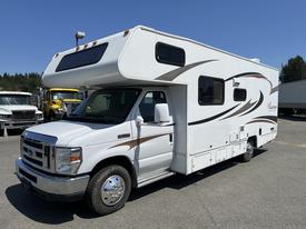 A white 2012 Ford Econoline motorhome with a sloping roof and decorative brown stripes on the side