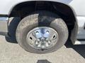 A chrome wheel and tire from a 2012 Ford Econoline with visible tread and dirt on the rubber surface