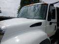 A 2015 International 4400 truck with a white cab and prominent front grille viewed from a slight angle showcasing the windshield and side mirror