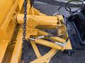 Close-up of a yellow hydraulic mechanism with connections and hoses on a 2006 Freightliner M2 106 truck attachment system