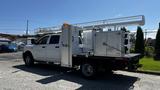 A white 2019 RAM 3500 truck with a utility bed featuring storage compartments and a mounted ladder rack