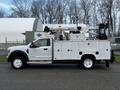 A 2018 Ford F-550 truck equipped with a white utility body and a lifted aerial work platform on top for maintenance and repair tasks