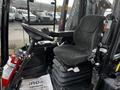 A 2020 Jacobsen HR800 lawn mower cockpit featuring a black mesh seat control panel and fire extinguisher with a floor mat reading you have been serviced