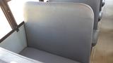 Interior view of a 2014 International 3000 school bus showing a gray padded bench seat with a smooth surface and no visible occupants