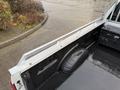 A 2017 Ford F-350 Super Duty truck bed with a black rubber bed mat and metal railings along the sides