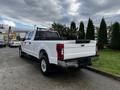 A 2020 Ford F-250 Super Duty pickup truck in white with a black truck bed and a mesh headboard