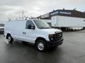 White 2013 Ford Econoline van with side doors and a ladder rack on the roof