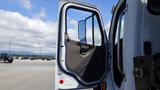 A 2017 Freightliner M2 106 truck with an open door, revealing the interior and side mirror of the vehicle