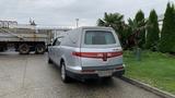 A silver 2013 Lincoln MKT hearse parked with its rear toward the viewer showcasing its elongated body and distinctive tail lights