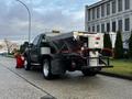 A 2012 Ford F-550 truck with a salt spreader attachment and a front snow plow