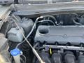 Engine compartment of a 2012 Kia Sportage showing various components including the engine block hoses and fluid reservoirs