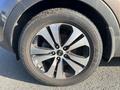 Close-up of a 2012 Kia Sportage wheel featuring a polished silver five-spoke rim mounted on a Dunlop tire