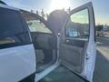 A white 2013 Ford Expedition with an open door revealing a beige interior and dashboard