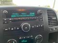 The dashboard display of a 2013 Chevrolet Silverado Hybrid showing radio settings and time with digital readouts