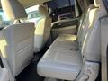 Interior view of the rear seating area of a 2013 Ford Expedition with light-colored leather seats and a spacious layout