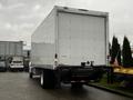 A 2020 Hino 338 box truck with a white exterior and a closed rear door parked in a lot