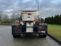 A 2012 Ford F-550 truck with a salt spreader attached at the rear showcasing an industrial design and utility features