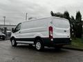 A white 2016 Ford Transit van parked with a simple design and black accents on the lower body and wheels