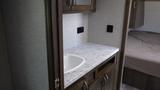 A marble countertop with a sink and wooden cabinetry in a camper interior