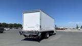 A 2019 International 4300 box truck with a white cargo area and rear doors, positioned prominently in an open space