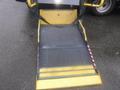 A metal wheelchair ramp designed for a 2016 Chevrolet Express with a textured surface and yellow safety features