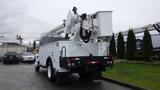 A 2005 International 4300 utility truck with an articulated aerial lift mounted on the back and equipped with a white bucket for reaching high areas