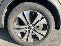 Close-up of a 2012 Kia Sportage wheel showing a multi-spoke alloy rim and a tire with the brand Grandtrek visible on the sidewall