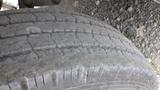 Close-up of a worn tire tread from a 2021 Forest River Cedar Creek showing visible grooves and dirt accumulation