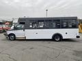 A 2017 Chevrolet Express shuttle bus with a white body and a black roof featuring large windows and a side entry door