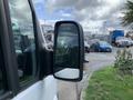 A 2017 Mercedes-Benz Sprinter van's side mirror reflecting the surroundings