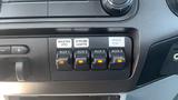 Control panel of a 2011 Ford F-450 SD featuring four illuminated auxiliary switches labeled AUX 1 to AUX 4 and buttons for MASTER PTO, STROBE LIGHTS, and INVER TOR