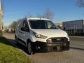 A white 2022 Ford Transit Connect van parked with side doors open and a black front grille