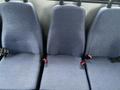 Three blue fabric seats with seatbelts inside a 2012 Chevrolet Express van