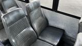 Interior view of a 2014 Freightliner Thomas diesel bus featuring gray vinyl seats arranged in a row with a sleek design and vertical stitching